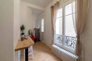 een kamer met een tafel en een groot raam bij LA BELLE VIE - Appartement cosy au centre-ville in Auxerre