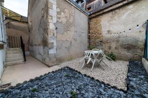 een tafel en stoelen op een binnenplaats met een gebouw bij LA BELLE VIE - Appartement cosy au centre-ville in Auxerre