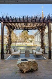 a wooden pergola with two chairs and a table and a rock at Magnolia Hotel in Jacksonville
