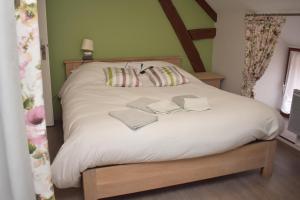 uma cama branca com dois livros em cima em Auberge Saint Fergeux em Gionges