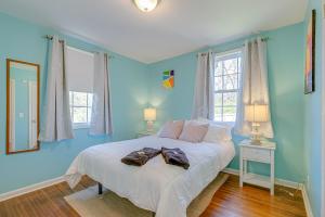 a bedroom with a bed with blue walls and windows at The Titan - Pet-friendly Bungalow in Nashville