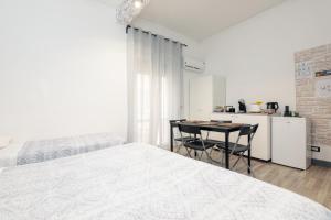 ジェノヴァにあるLe Mura room&breakfastの白いベッドルーム(ベッド1台、テーブル、椅子付)