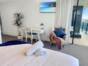 a hotel room with a bed and a desk and a table at 29th floor Oracle Tower 2 stunning ocean and city views in Gold Coast