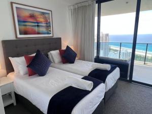two beds in a hotel room with a view of the ocean at 29th floor Oracle Tower 2 stunning ocean and city views in Gold Coast