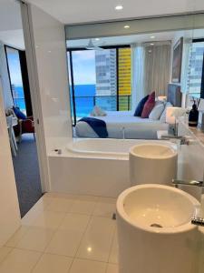 a bathroom with a bed and a tub and a sink at 29th floor Oracle Tower 2 stunning ocean and city views in Gold Coast