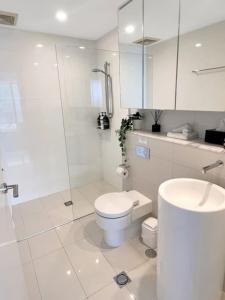 a bathroom with a toilet and a shower and a sink at 29th floor Oracle Tower 2 stunning ocean and city views in Gold Coast