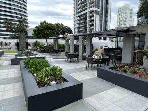 a patio with tables and chairs and an umbrella at 29th floor Oracle Tower 2 stunning ocean and city views in Gold Coast