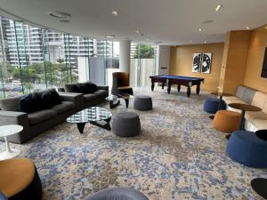 a living room with couches and a pool table at 29th floor Oracle Tower 2 stunning ocean and city views in Gold Coast