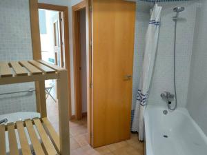 y baño con bañera y ducha con cortina de ducha. en Apartamento Plaza de San Bernardo 4, en Sevilla