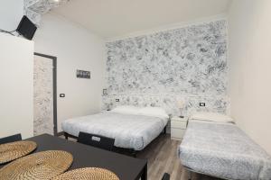 ジェノヴァにあるLe Mura room&breakfastのベッド2台、テーブル(帽子付)が備わる客室です。