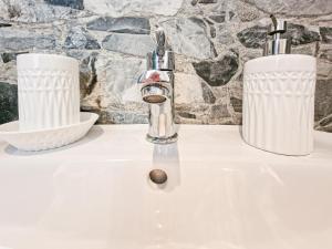 a bathroom sink with two white containers on it at Loft Francesca Old City Center in Rio Marina +18 photos