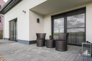 eine Terrasse mit Korbstühlen und ein Gebäude in der Unterkunft Luxus-Ferien-VILLA AMICI in Göhren-Lebbin