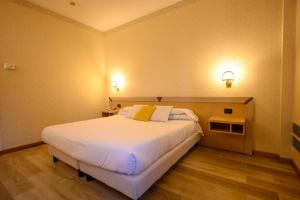 a bedroom with a large white bed in a room at Hotel Torre Di Pratolungo in Casal Monastero