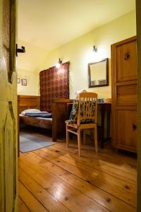 a bedroom with a bed and a desk and a chair at Modryna Ranczo in Krasiczyn