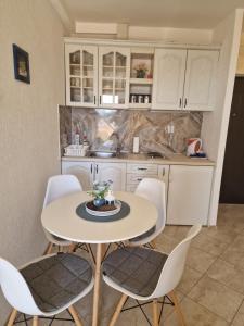 a kitchen with a white table and chairs at Marta apartment in Petrovac na Moru