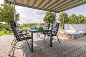 patio con mesa, sillas y bañera de hidromasaje en Luxus_SPA_EG_Fewo AQUAMARIN _WE 1_, en Göhren-Lebbin