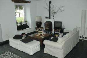 sala de estar con 2 sofás blancos y TV en VILLA junto a la Ría del Eo, en CASTROPOL Asturias, en Castropol