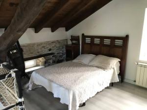 1 dormitorio con cama y pared de piedra en VILLA junto a la Ría del Eo, en CASTROPOL Asturias, en Castropol