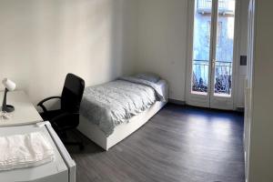 een slaapkamer met een bed, een bureau en een stoel bij Belle et agréable maison de ville 9 chambres in Saint-Étienne