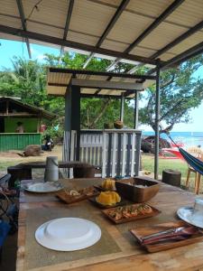 een houten tafel met borden eten erop bij Tupi's Beachfront Minihouse in Bacungan