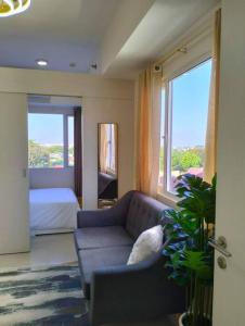 ein Wohnzimmer mit Sofa und ein Schlafzimmer in der Unterkunft Cozy Flexi 1BR or 2BR condo at Southmall Las Pinas in Manila