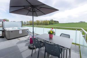 eine Terrasse mit einem Tisch, Stühlen und einem Sonnenschirm in der Unterkunft VILLA MON BIJOU / OG-Fewo in Göhren-Lebbin