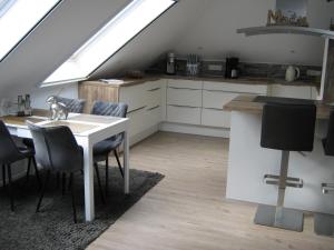 a kitchen and dining room with a table and a window at Ferienwohnung Storchennüst in Aurich