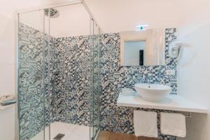 a bathroom with a glass shower with a sink at Casa Al Vicolo in Taormina