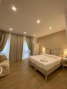 a bedroom with a large white bed and two windows at Casa Al Vicolo in Taormina