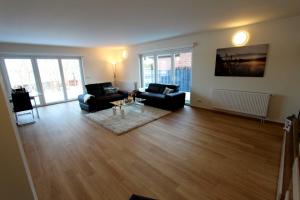 a living room with two couches and a table at VILLA SEE_RESIDENZ in Malchow