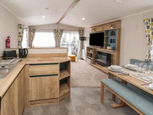 a kitchen with wooden cabinets and a table with a tv at Walkers Retreat in Ganton