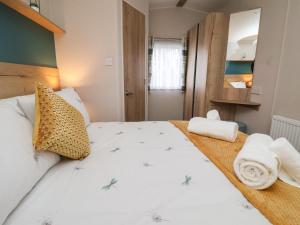 a bedroom with a large bed with towels on it at Walkers Retreat in Ganton