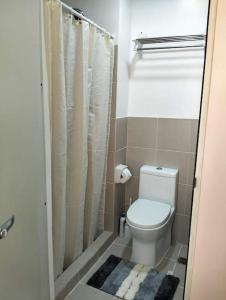 a small bathroom with a toilet and a shower at Cozy Flexi 1BR or 2BR condo at Southmall Las Pinas in Manila