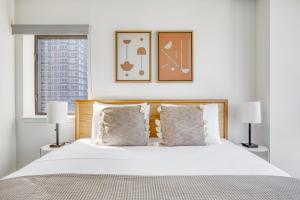 a bedroom with a large white bed with two lamps at Midtown W 2BR w Gym WD nr Times Sq NYC-898 in New York