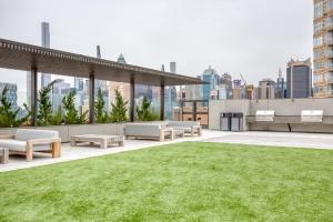 a rooftop patio with grass and a view of the city at Midtown W 2BR w Gym WD nr Times Sq NYC-898 in New York
