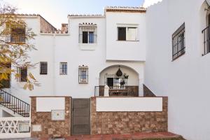 a white building with a staircase in front of it at Almijarahouse in Nerja