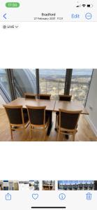 a table and chairs in a room with a window at Shared with Host Lister Pods Executive Penthouse in Bradford