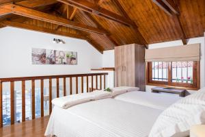 プラタニアスにあるSea View House Plataniasの白いベッドと木製の天井が備わるベッドルーム1室が備わります。