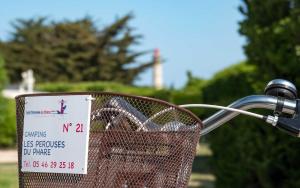 a basket on a bike with a sign on it at Camping Les Perouses in Saint-Clément-des-Baleines
