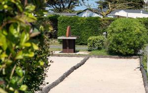 a garden with a bench and a hedge at Camping Les Perouses in Saint-Clément-des-Baleines