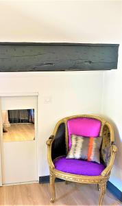 une chaise violette dans une pièce avec cheminée dans l'établissement Marseille-au-bord-de-l'eau, à Marseille