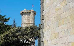 a brick tower with a flag on top next to a building at Camping Les Perouses in Saint-Clément-des-Baleines