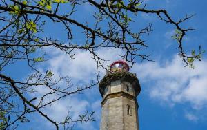 a lighthouse with a red clock on top of it at Camping Les Perouses in Saint-Clément-des-Baleines