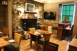 a restaurant with a table and chairs and a fireplace at The Inn At Kingsbarns in St Andrews