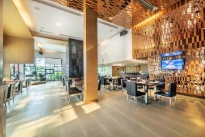 a restaurant with tables and chairs and a bar at M2 de Bangkok Hotel in Bangkok