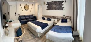 a hotel room with two beds and a couch at Hotel Bella Dolores in Lloret de Mar +38 photos