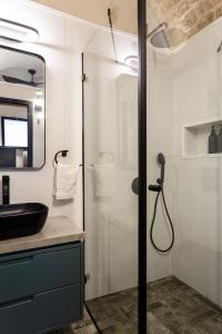 uma casa de banho com uma cabina de duche em vidro e um lavatório. em Mirsa em Acre