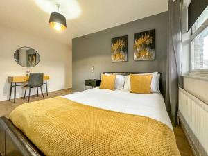 a bedroom with a large bed with a yellow blanket at Newly Refurbished 3 Bed House Near London o2 Arena in London