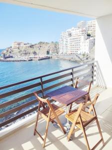 een tafel en 2 stoelen op een balkon met uitzicht op de oceaan bij Estudio al Mar in San Marcos