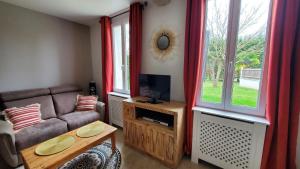 a living room with a couch and a window at Appart' Nature L'ESCALE - Saintes - Piscine, Parking, Terrasse, Wifi in Chaniers